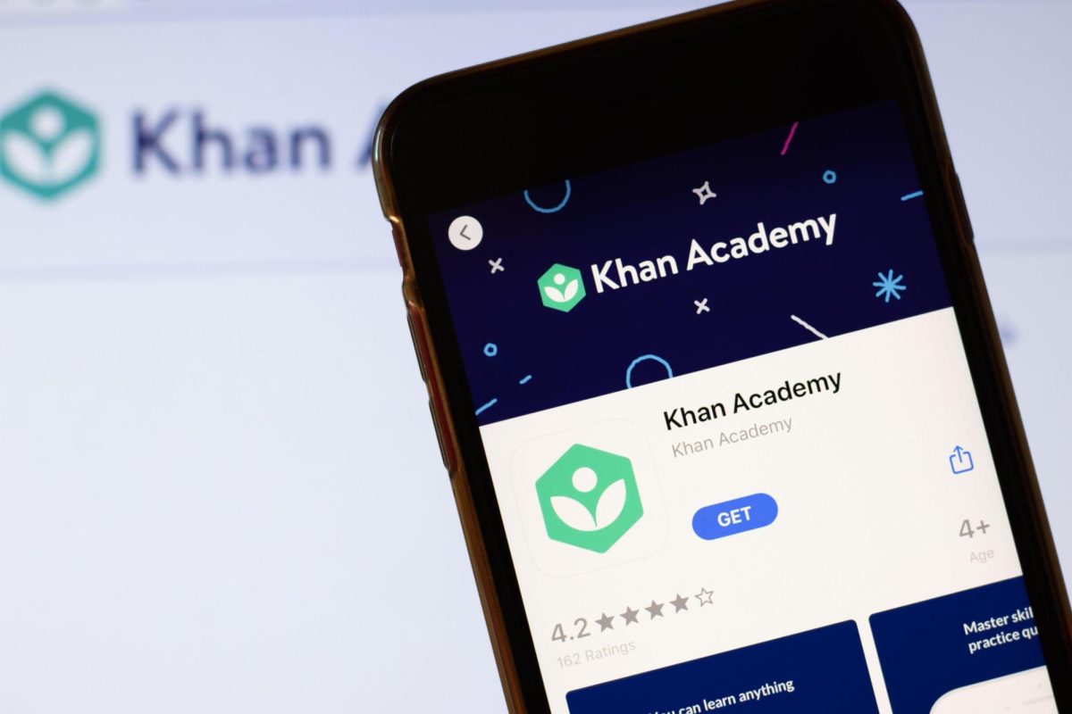 Khan Academy app logo on phone screen close up with website on background with icon.