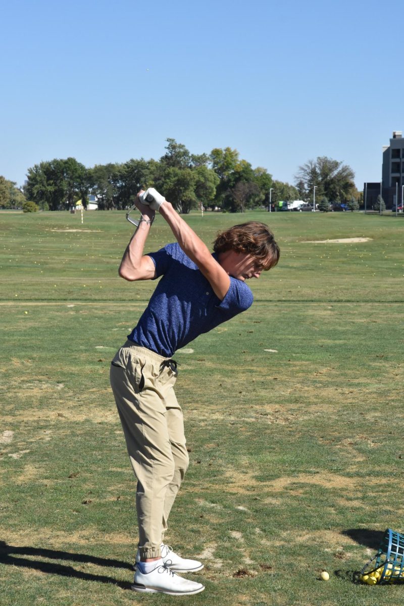 Nick Simon warms up for a golf meet